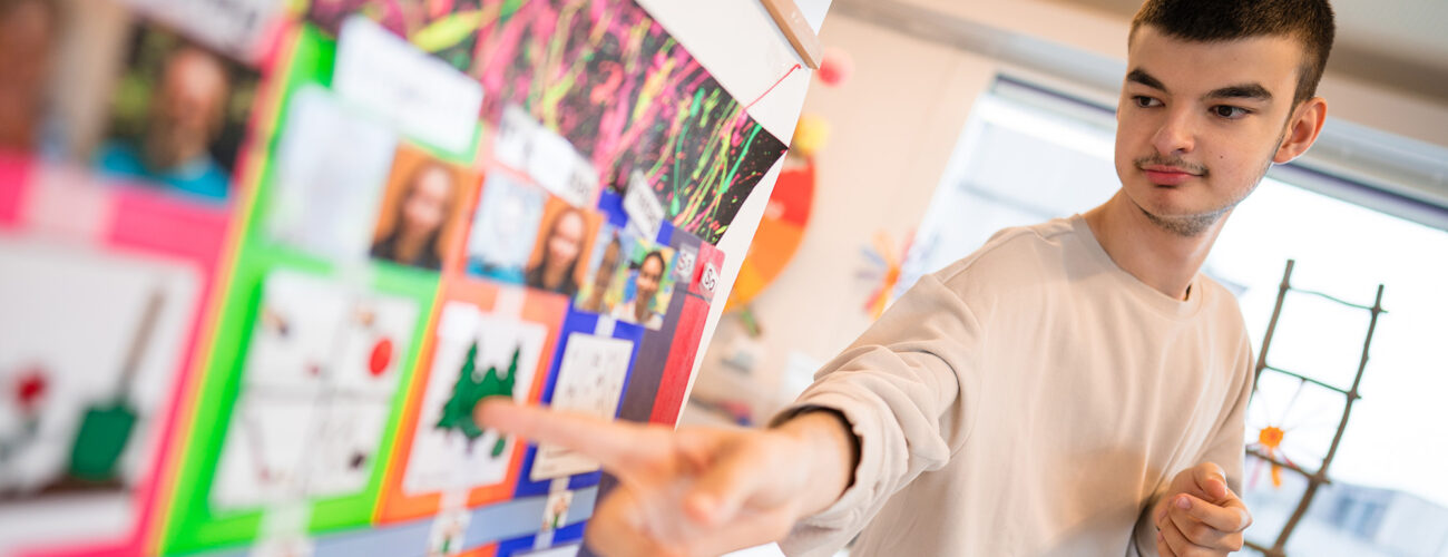 Ein Klient zeigt auf den Ämtliplan des Ateliers