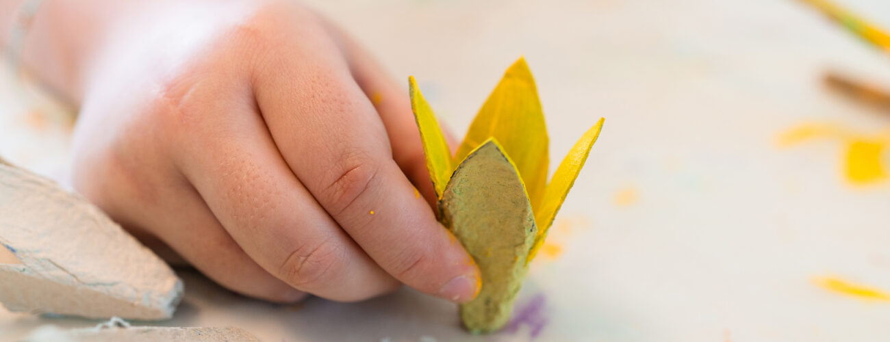 Eine Hand mit einer selbstgebastelten Blume