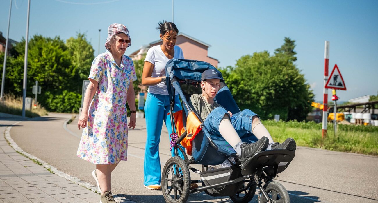 Drei Personen machen einen Spaziergang in der Sonne