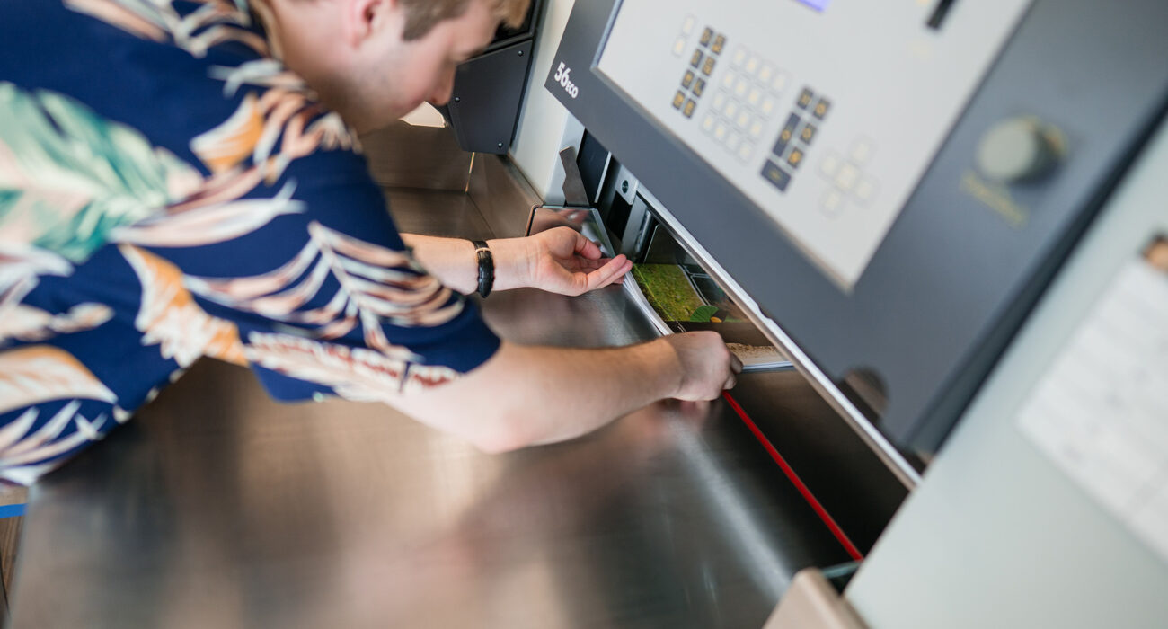 Ein Mitarbeiter bedient die Schneidemaschine