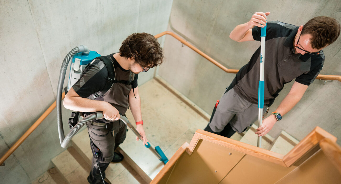 Zwei Mitarbeiter der Hauswartung reinigen das Treppenhaus