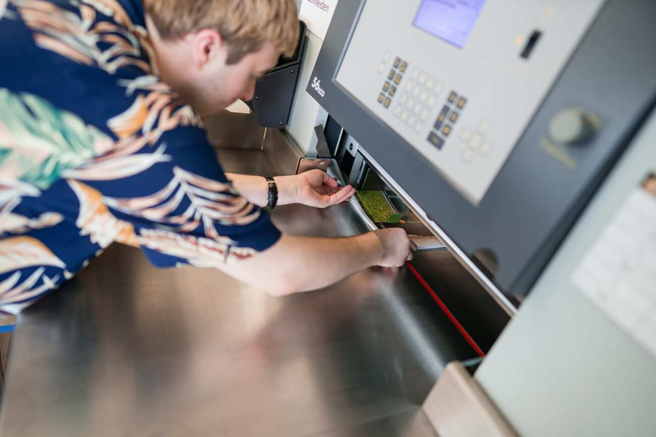 Ein Mitarbeiter bedient die Schneidemaschine